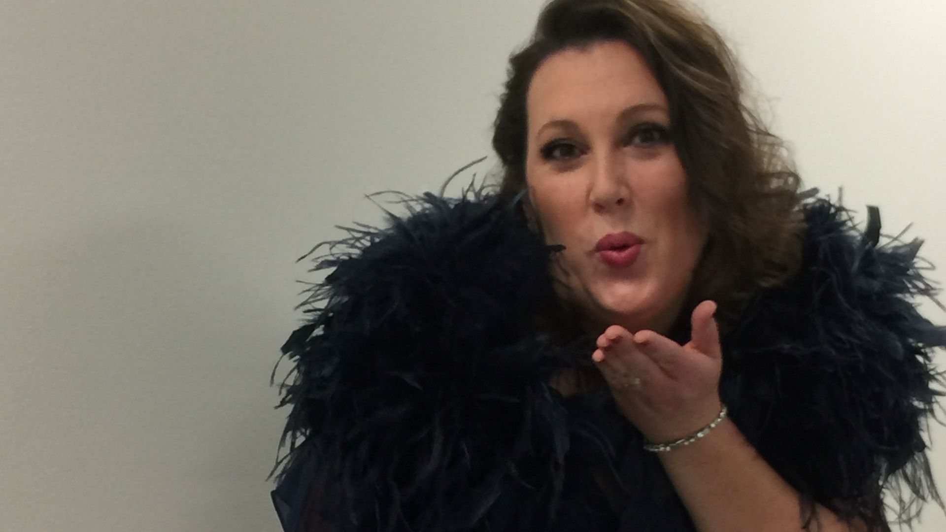 Jenny Leslie in black feathers at the ball and blowing a kiss