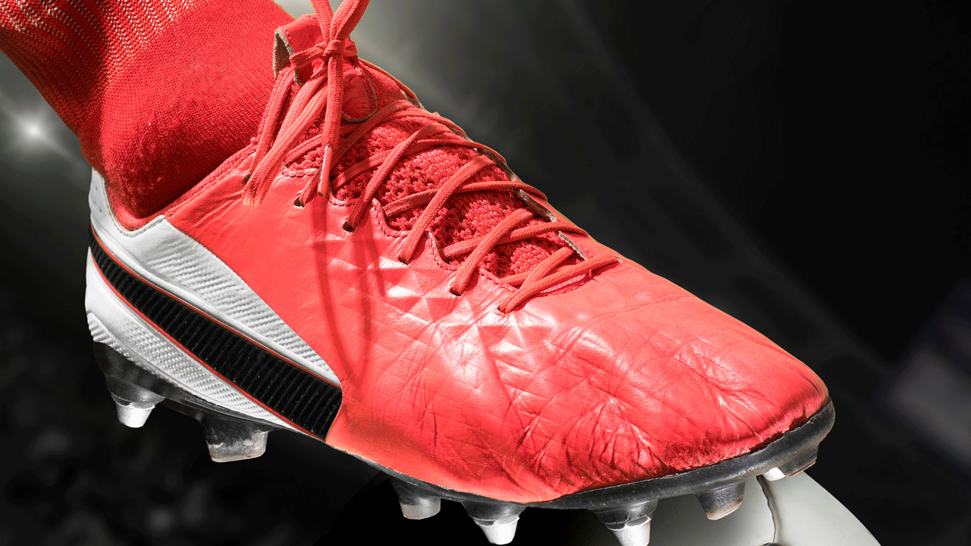 Red football boot perched on football