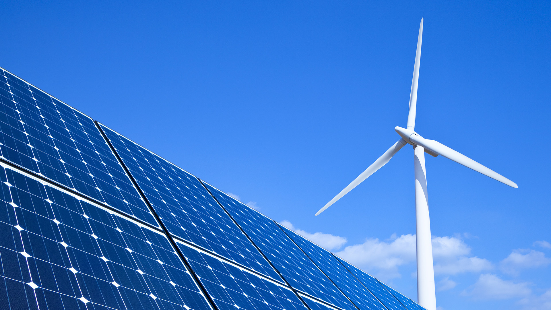 Solar panel and turbine under blue sky