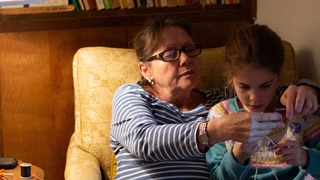 Mother teaching grand-daughter to crochet