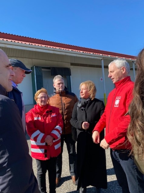 Governor Pataki near Ukrainian border meeting with Red Cross officials and government minister in front of warehouse with relief supplies for refugees