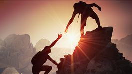 Hikers help each other on a mountain