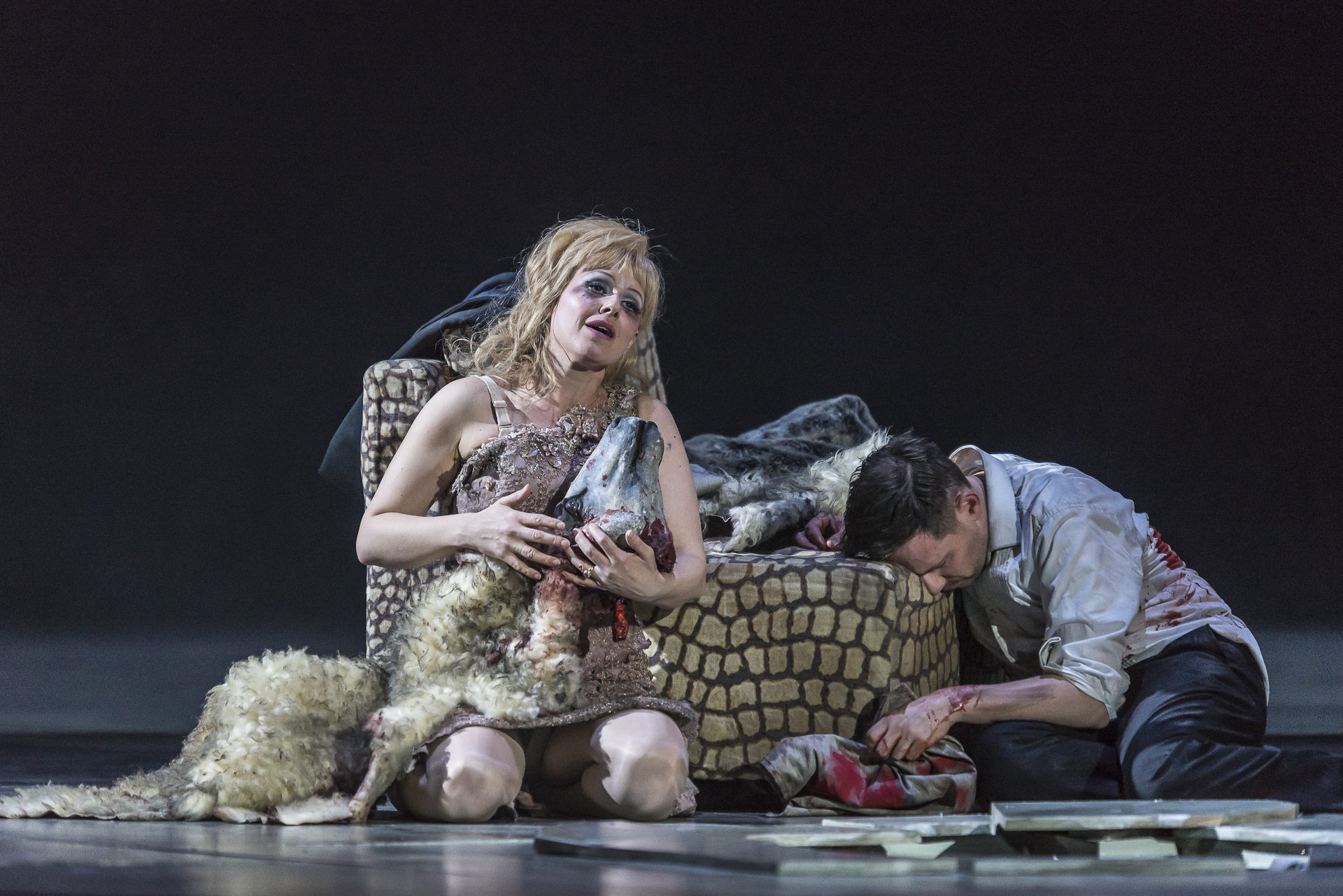scene from Exterminating Angel (Thomas Ades) opera at ROH, a woman in great distress clutches a sheep's head
