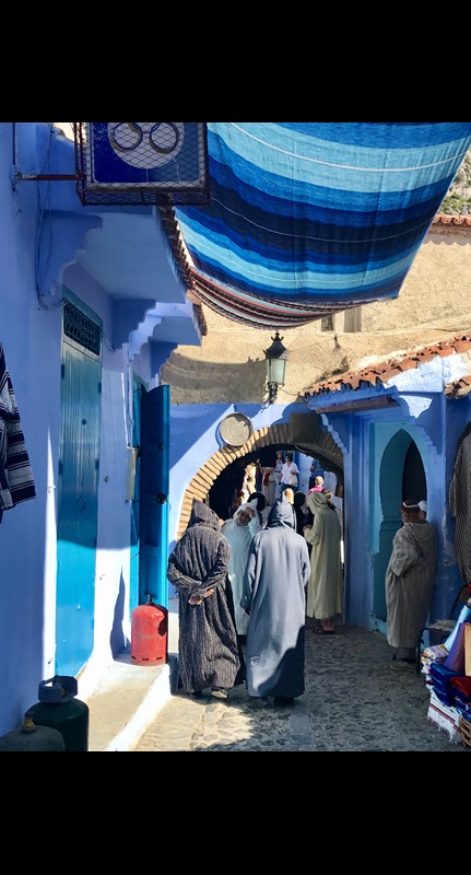 Two men in robes walking back streets of Chefchaouen
