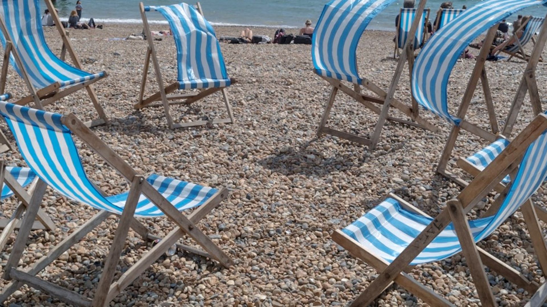a circle of empty deckchairs on Brighton beach by Mark Heathcote