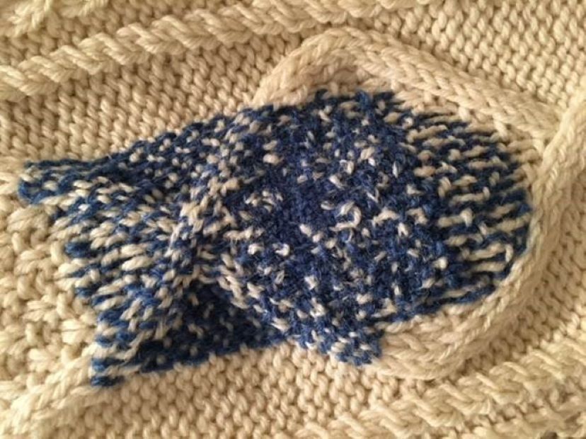 an example of Celia Pym's darning (blue wool on cream woollen garment)