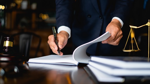 Judicial figure inspects a book
