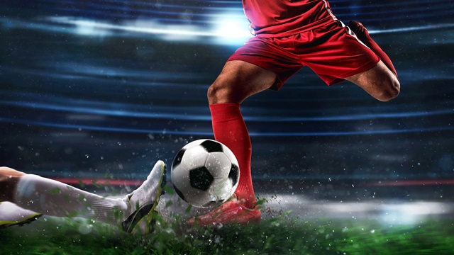 Two rival footballers contest a tackle