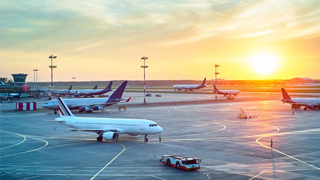 Airport with many airplanes at beautiful sunset