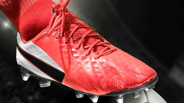 Red football boot perched on football