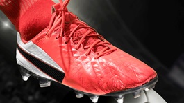 Red football boot perched on football