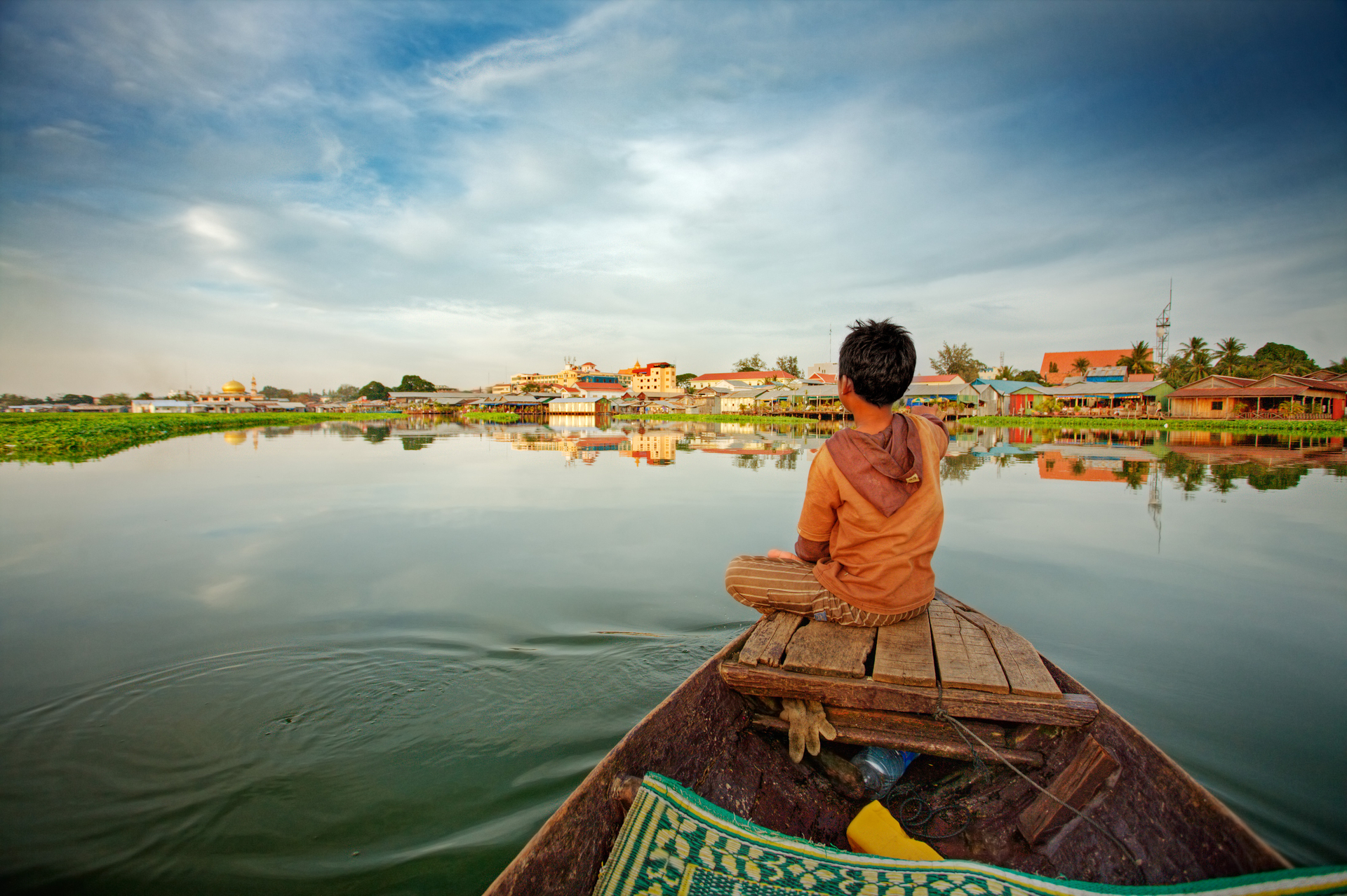 Lake in Cambodia, child sitting on a boat