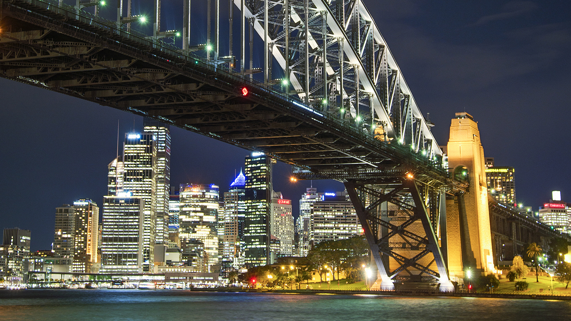 City bridge at night with downtown skyline behind it