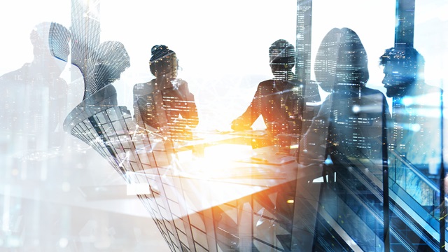 Image is of silhouettes of people at a boardroom table