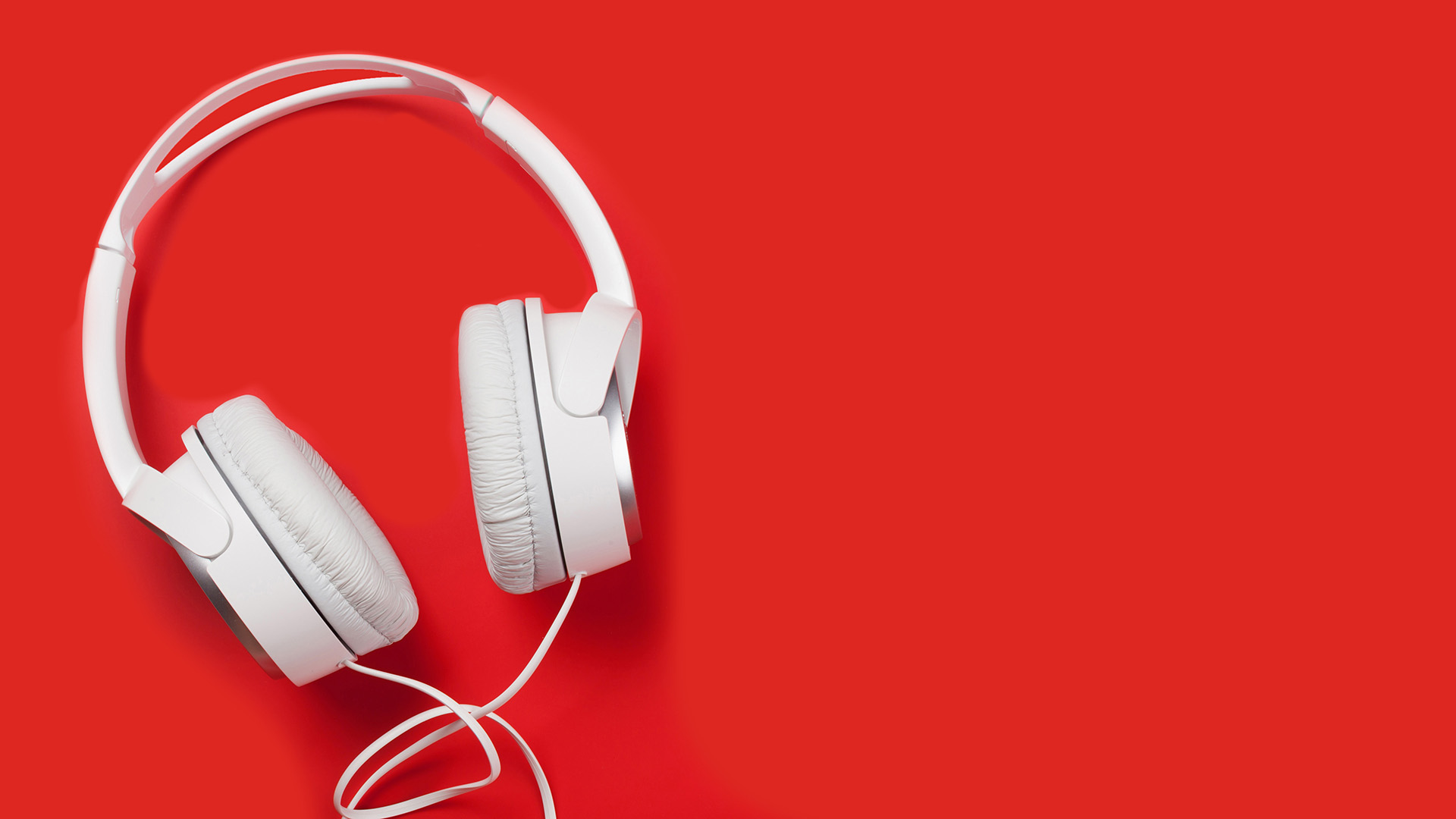 White headphones on top of a red background