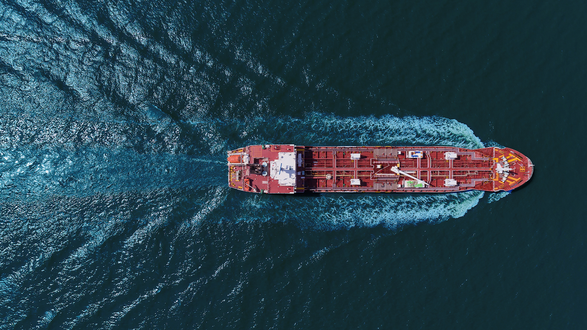 A ship sails on the sea, creating ripples