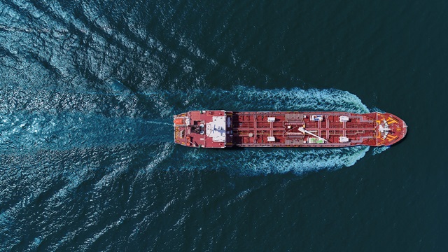 A ship sails on the sea, creating ripples
