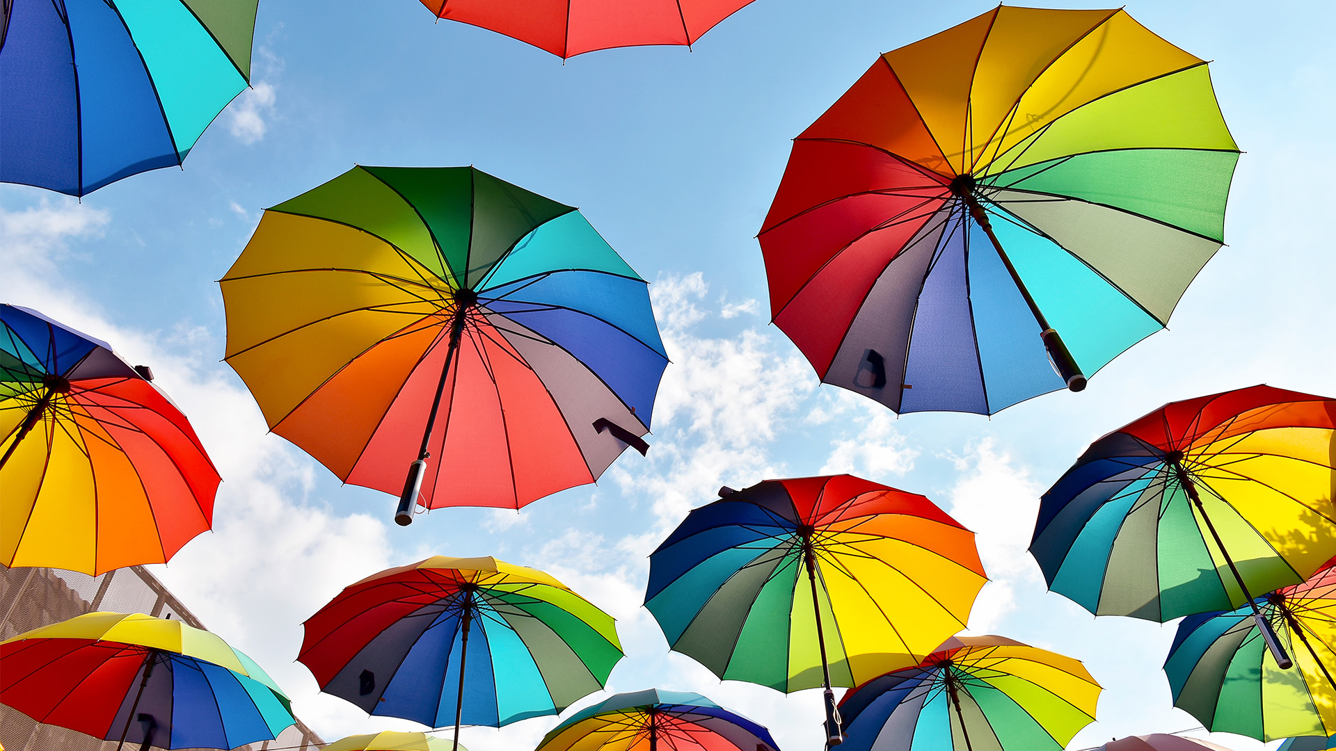 opened umbrellas with a rainbow pattern against the backdrop of the sky