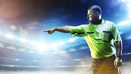 Sports referee pointing and whistling