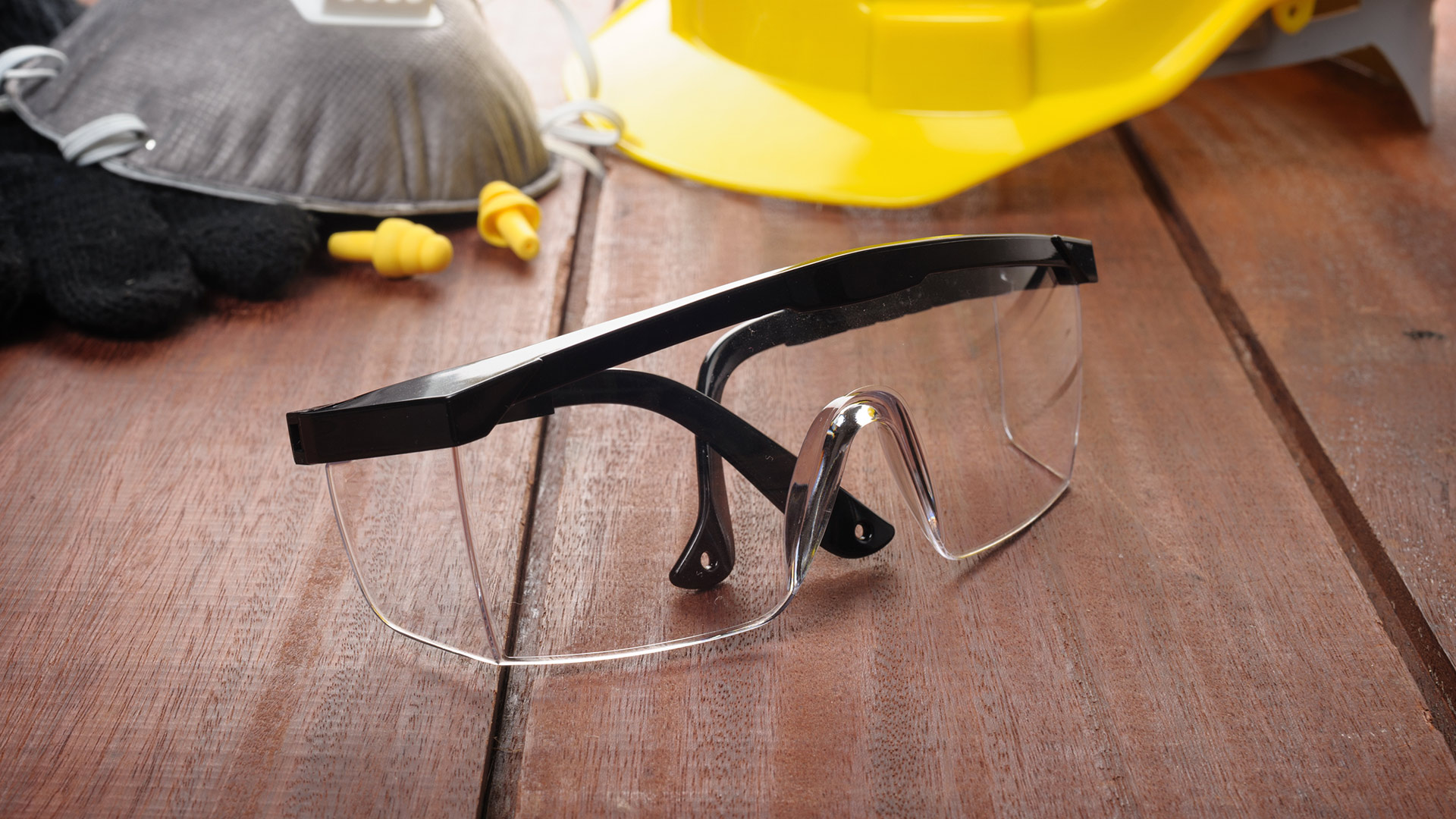 Safety glasses, a hardhat, mask and gloves sitting on a table