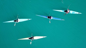 Image of four kayaks on blue water
