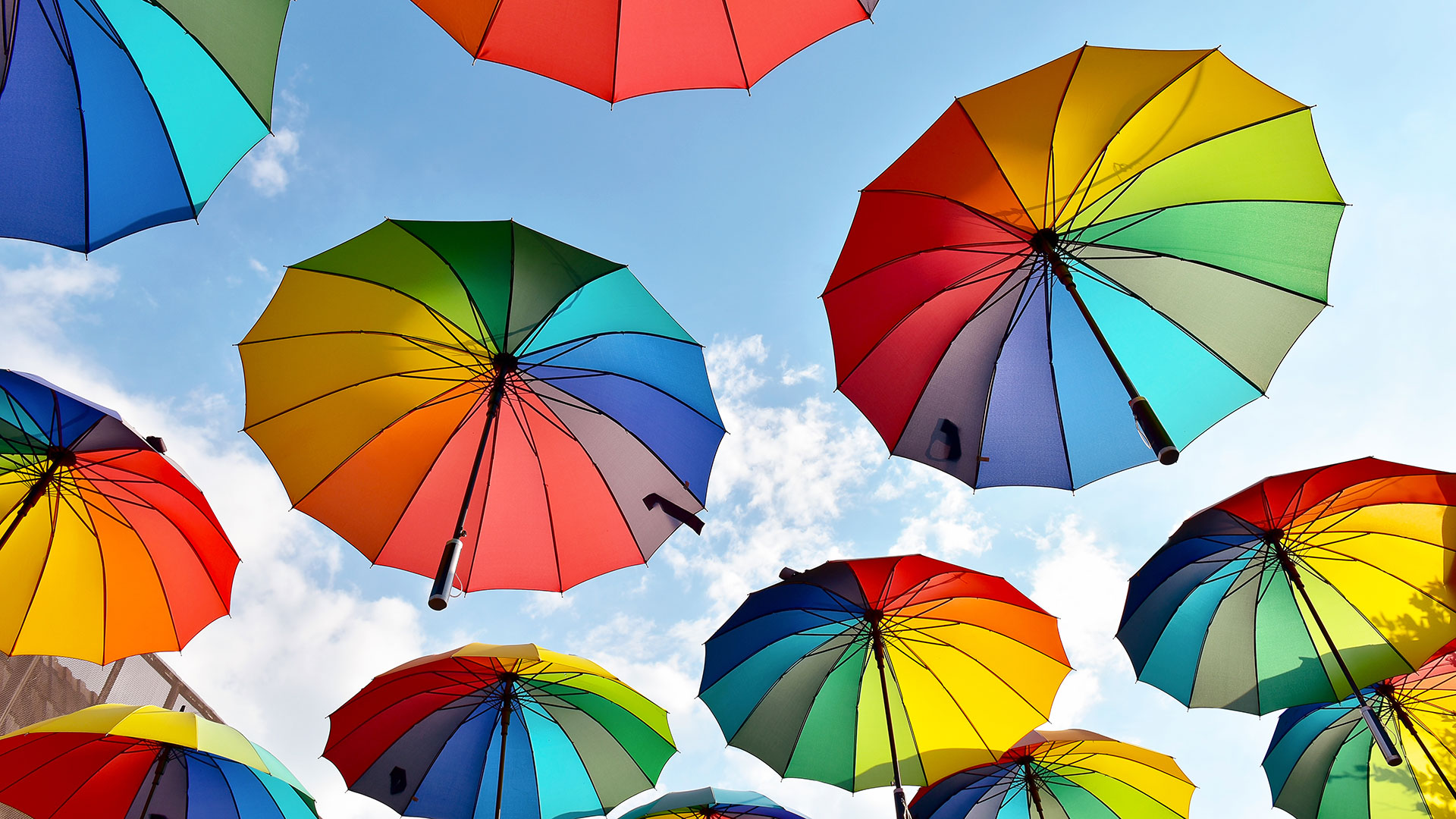 Image of multi-colored open umbrella's floating in sky