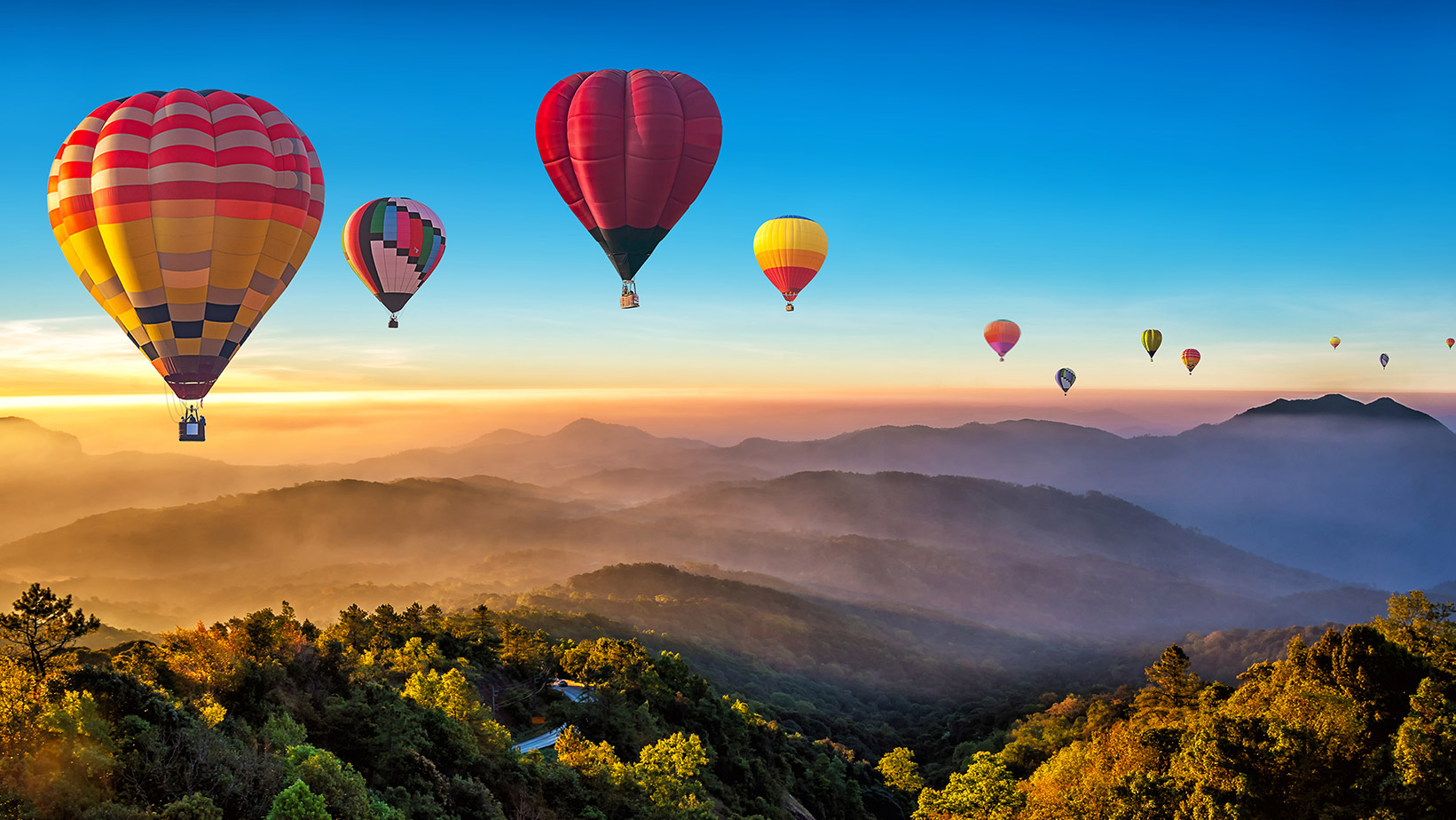 Balloons flying over a valley