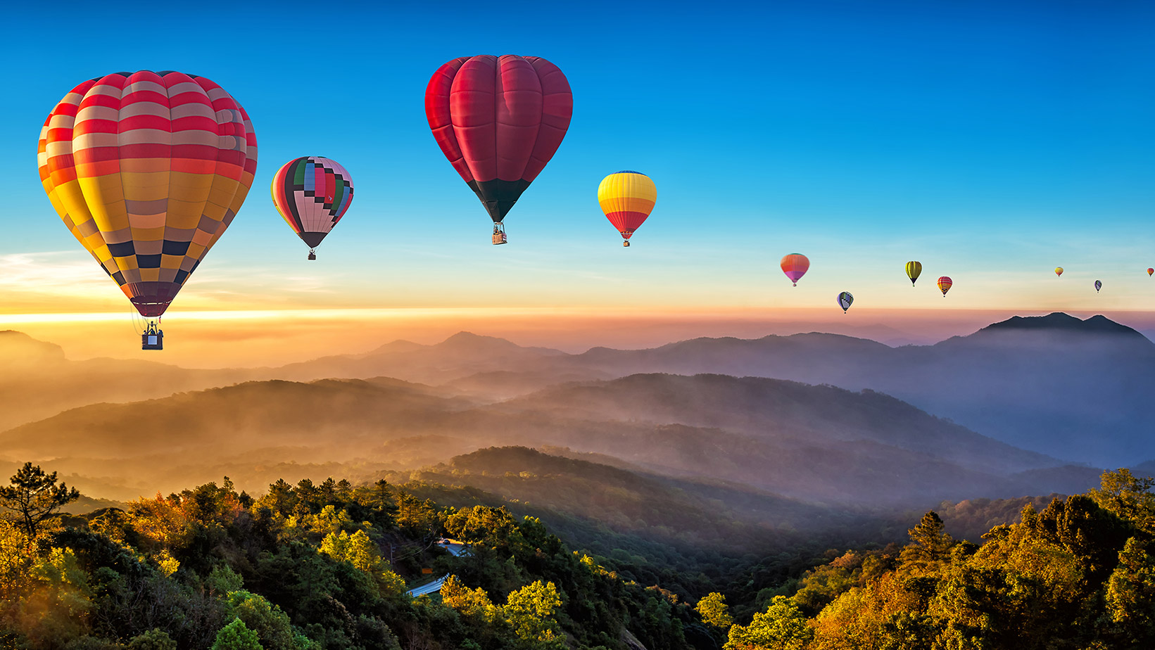 balloons flying over mountain range