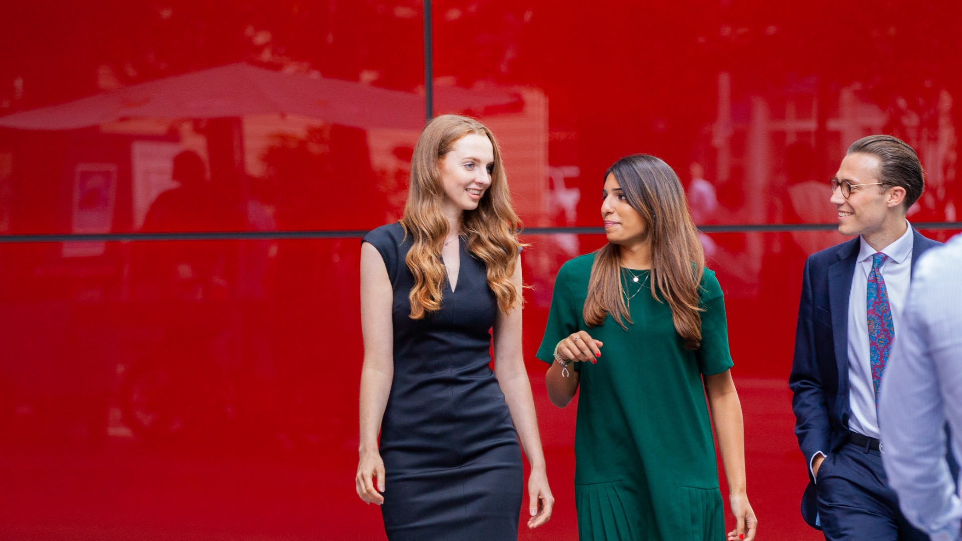 people walking in a red background
