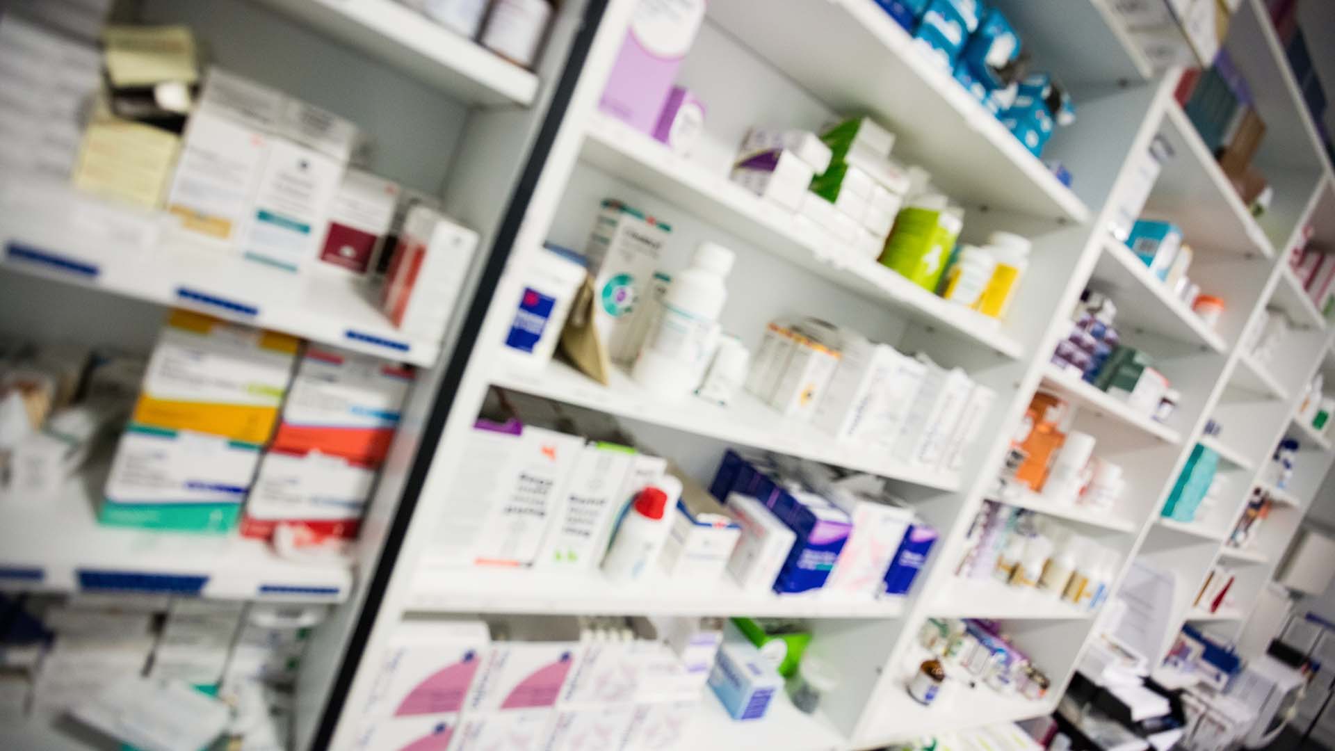 Pharmacy shelving with medication boxes and bottles