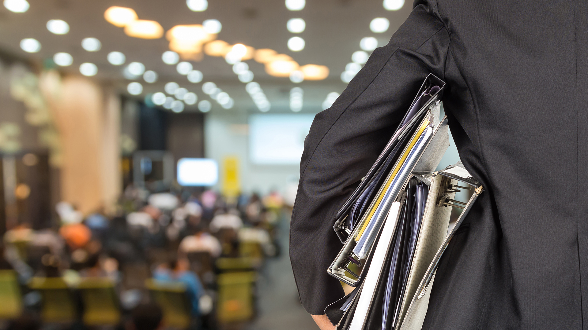 Person holding stacks of binders
