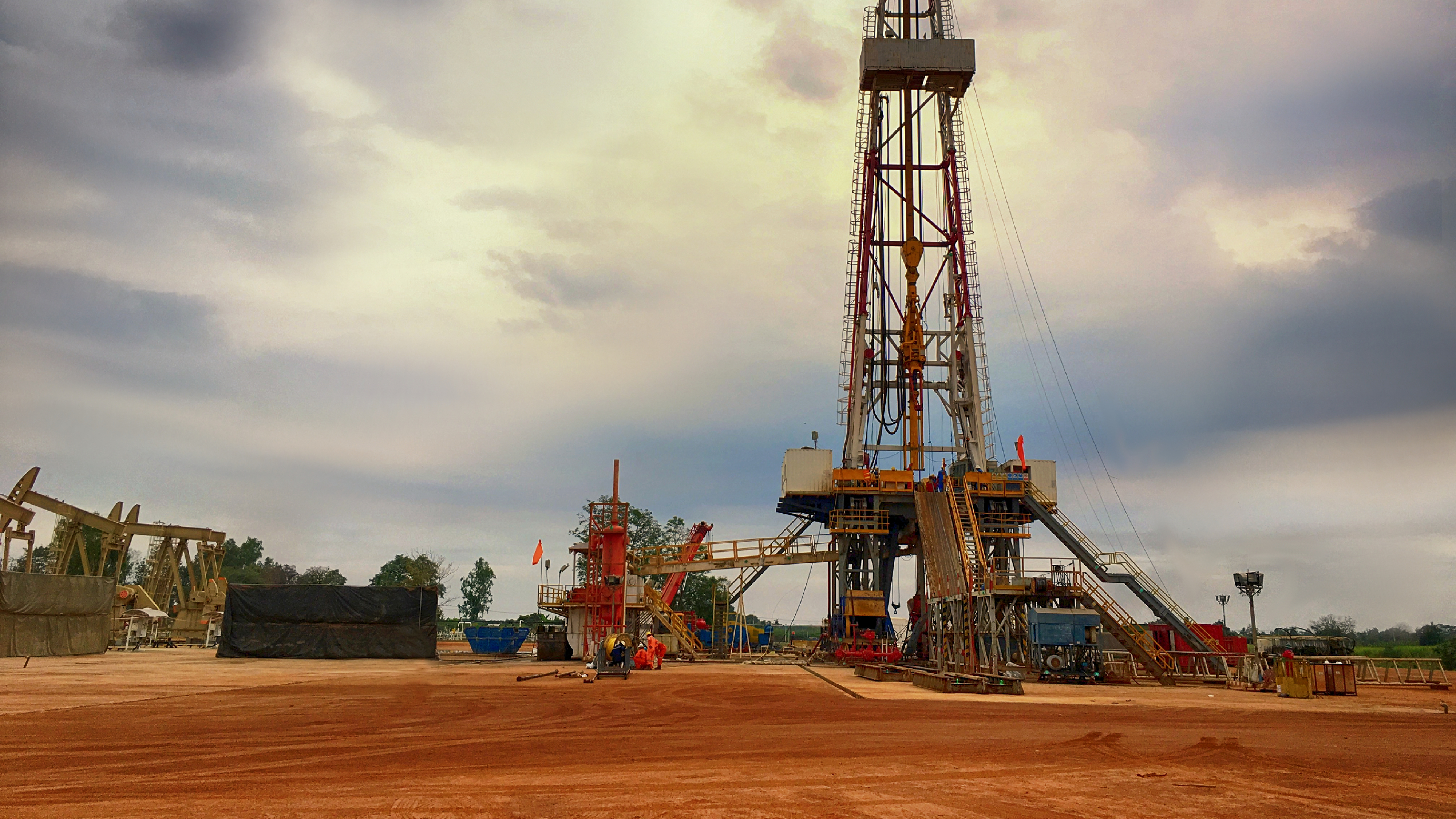 Oil field rig and derrick with clouds behind