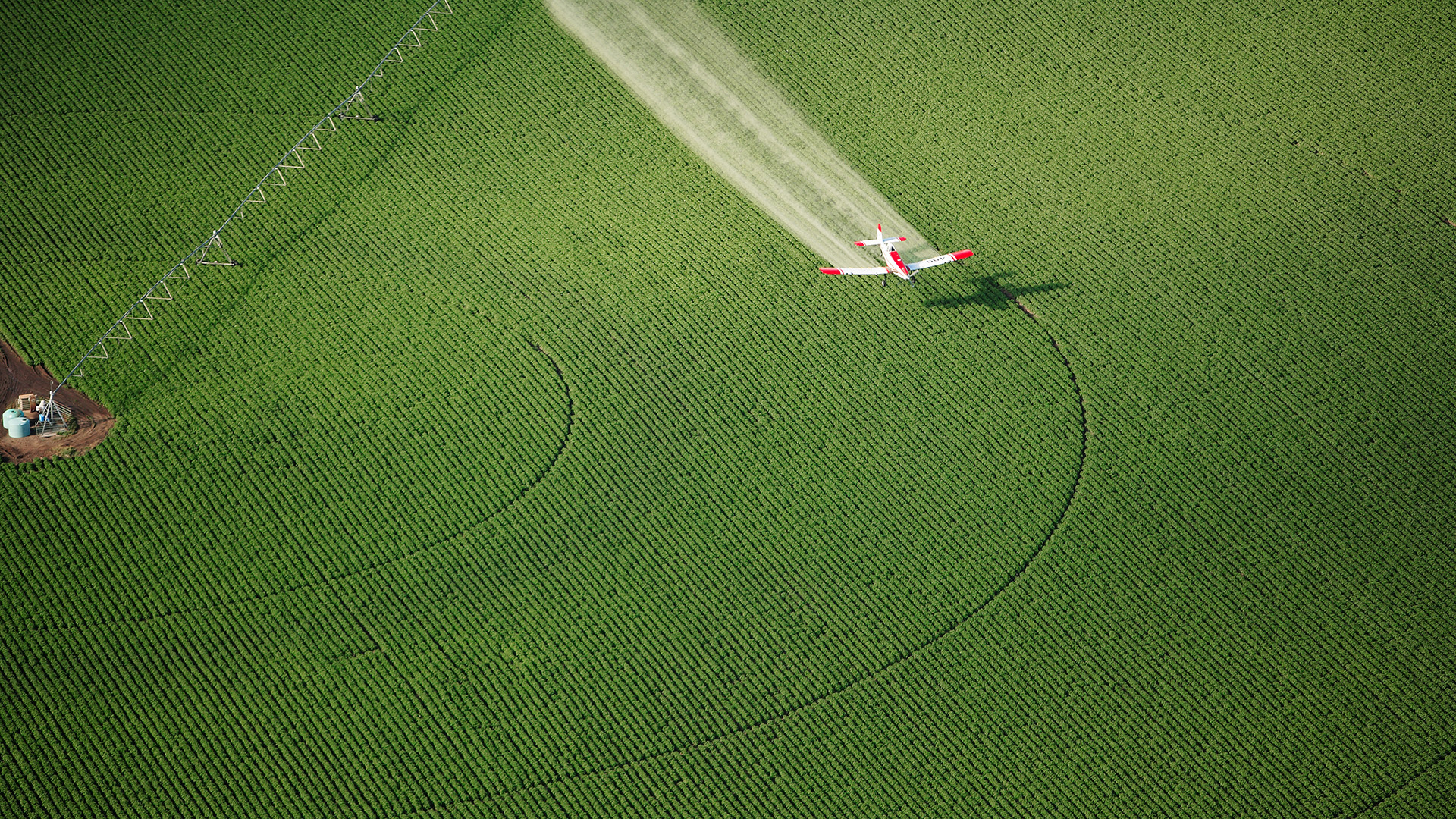Image of a plane flying over a field