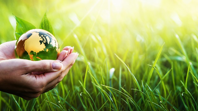 hands holding green environment globe
