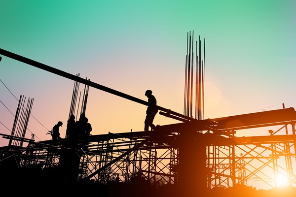 Silhouette of construction workers working on scaffolding 