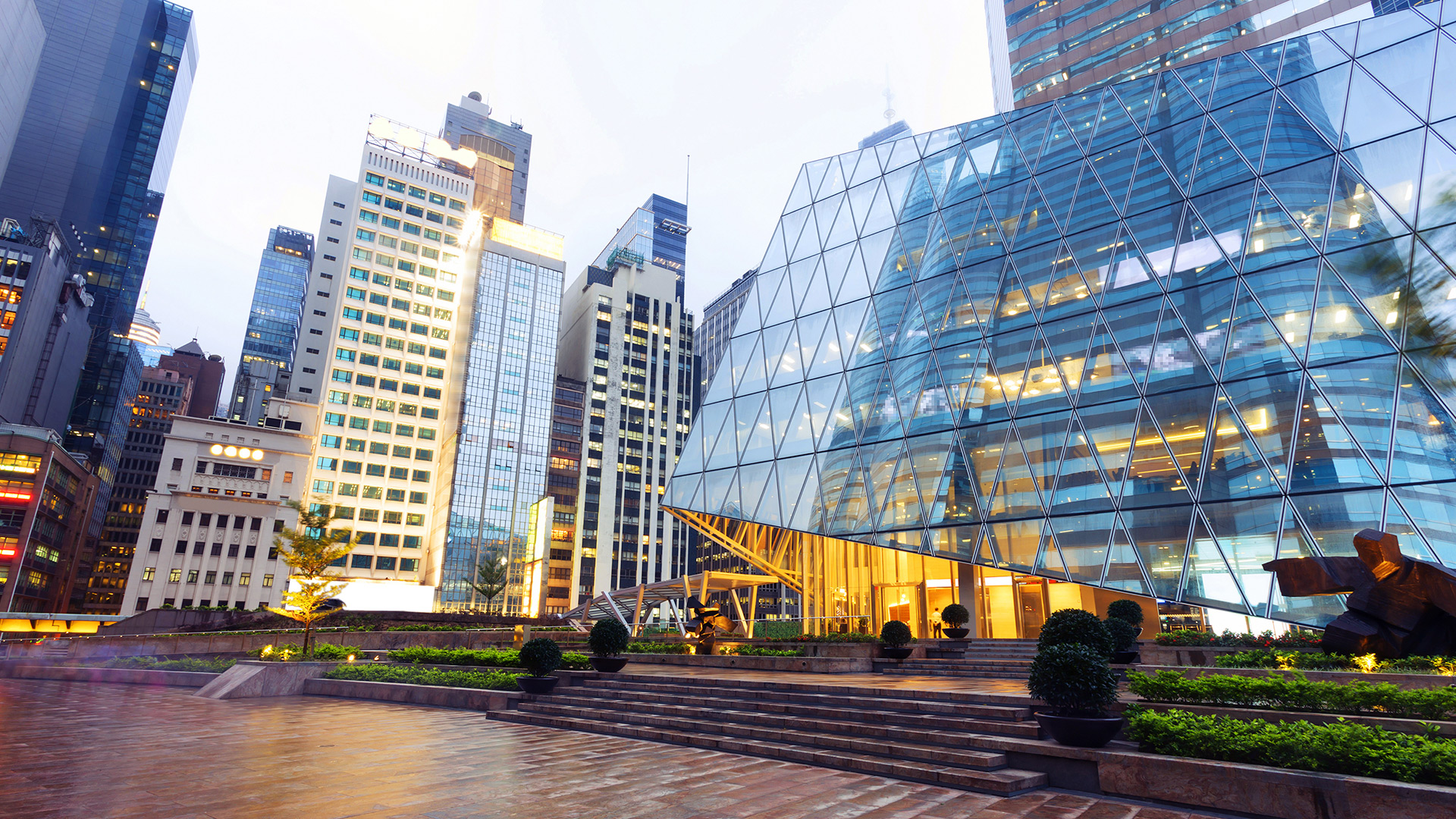 Several office buildings, geometric glass building in the foreground