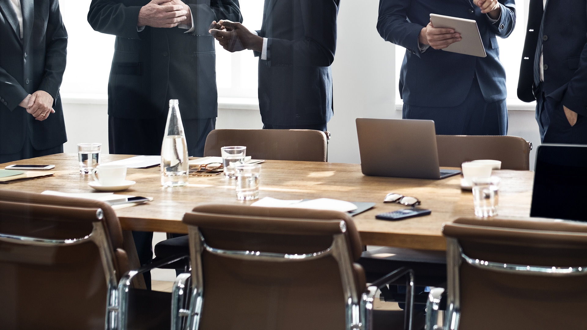 People standing around a boardroom table