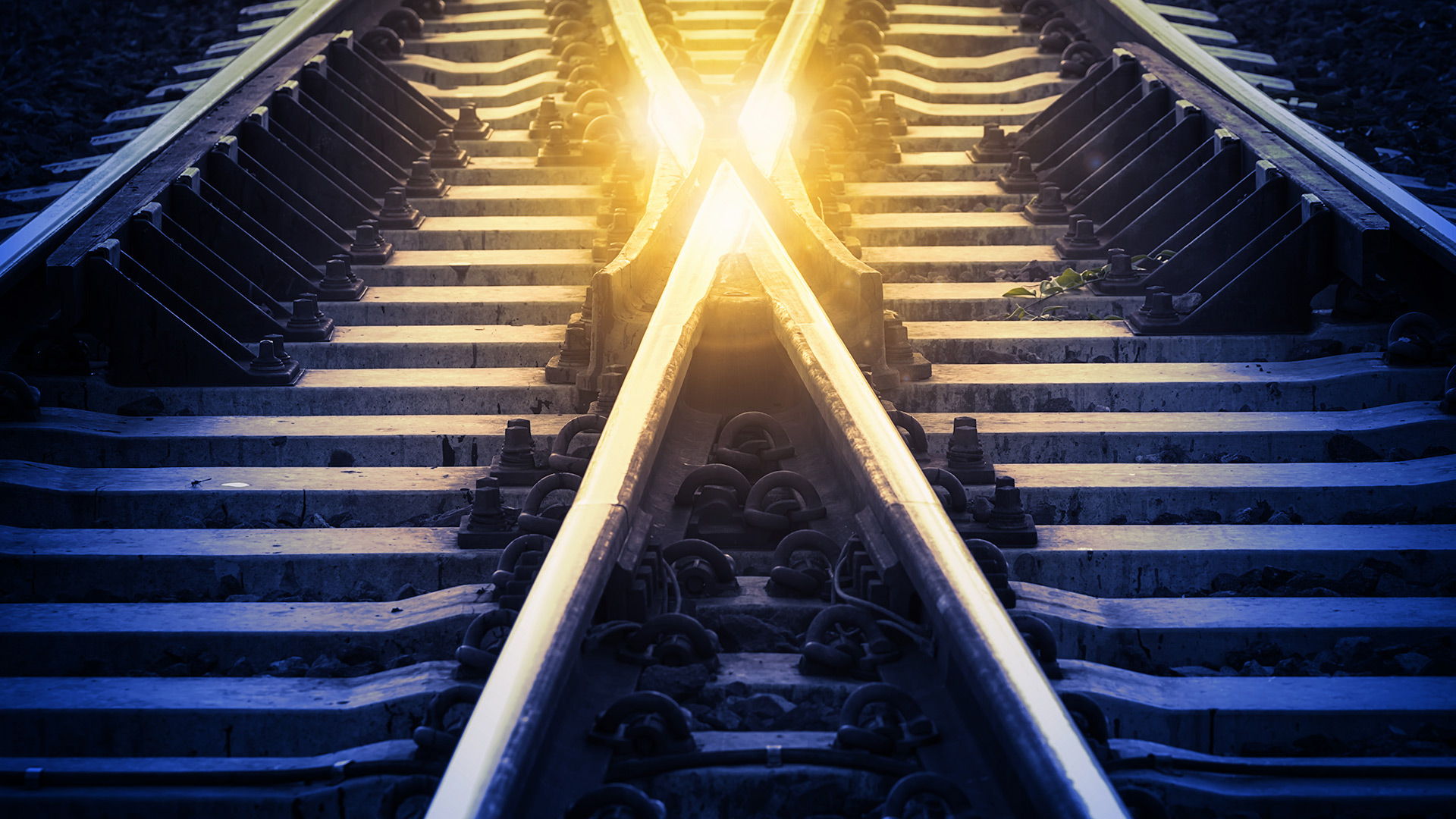 A light shining on two rail tracks coming together