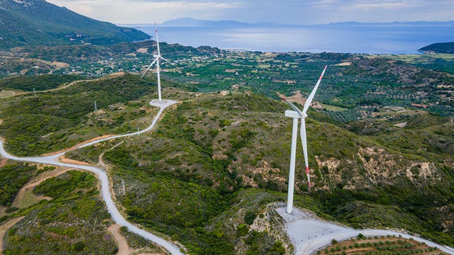 Wind turbine farm for energy production on sunrise sky at seacoast in Turkey