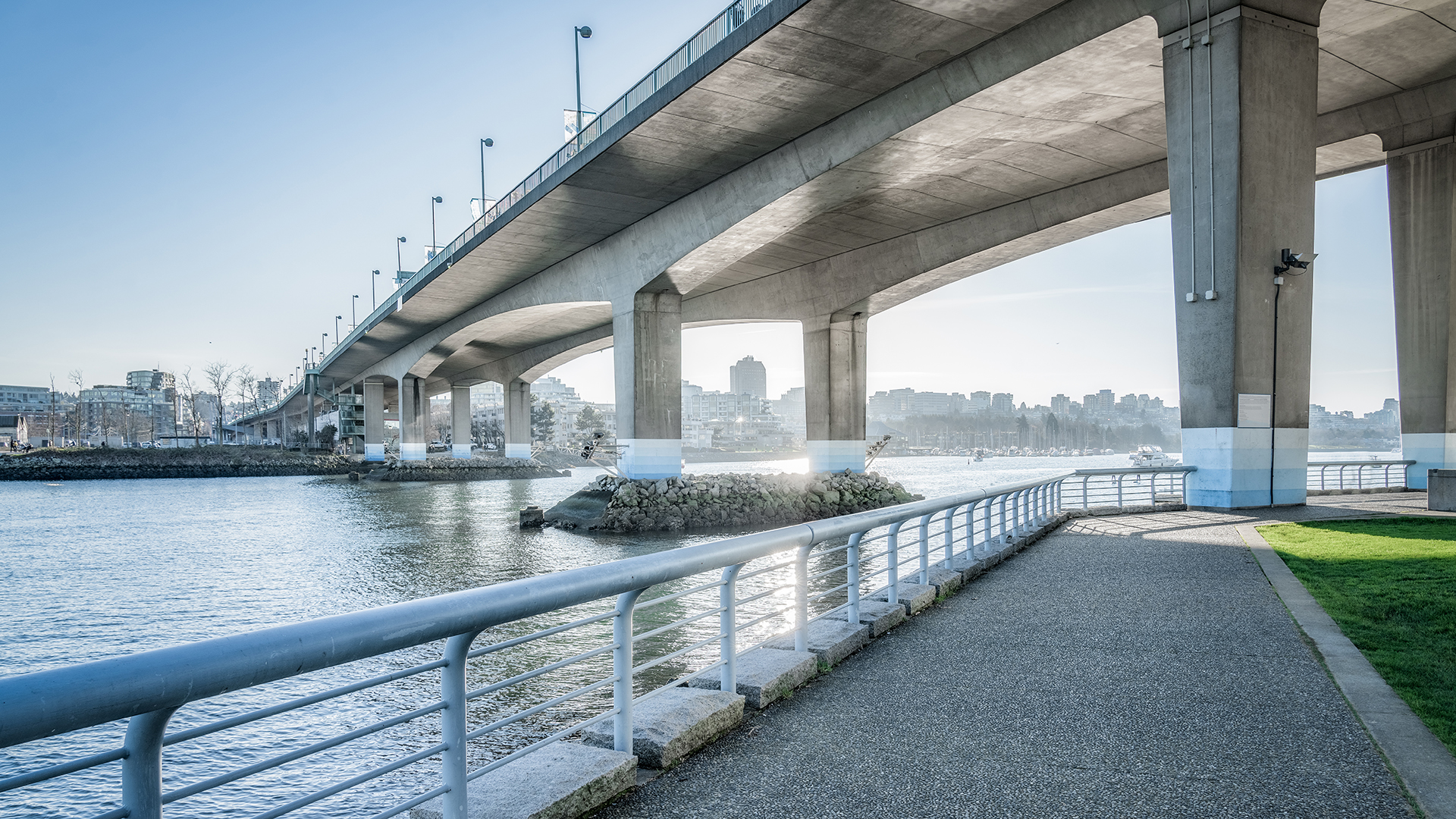 A walkway going under a bridge in the day