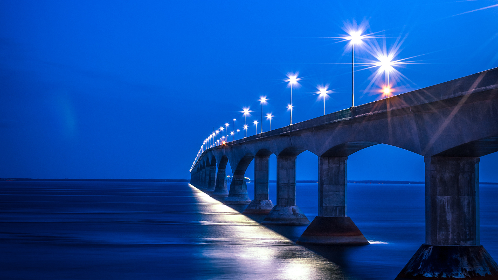 A bridge over water with lights at night