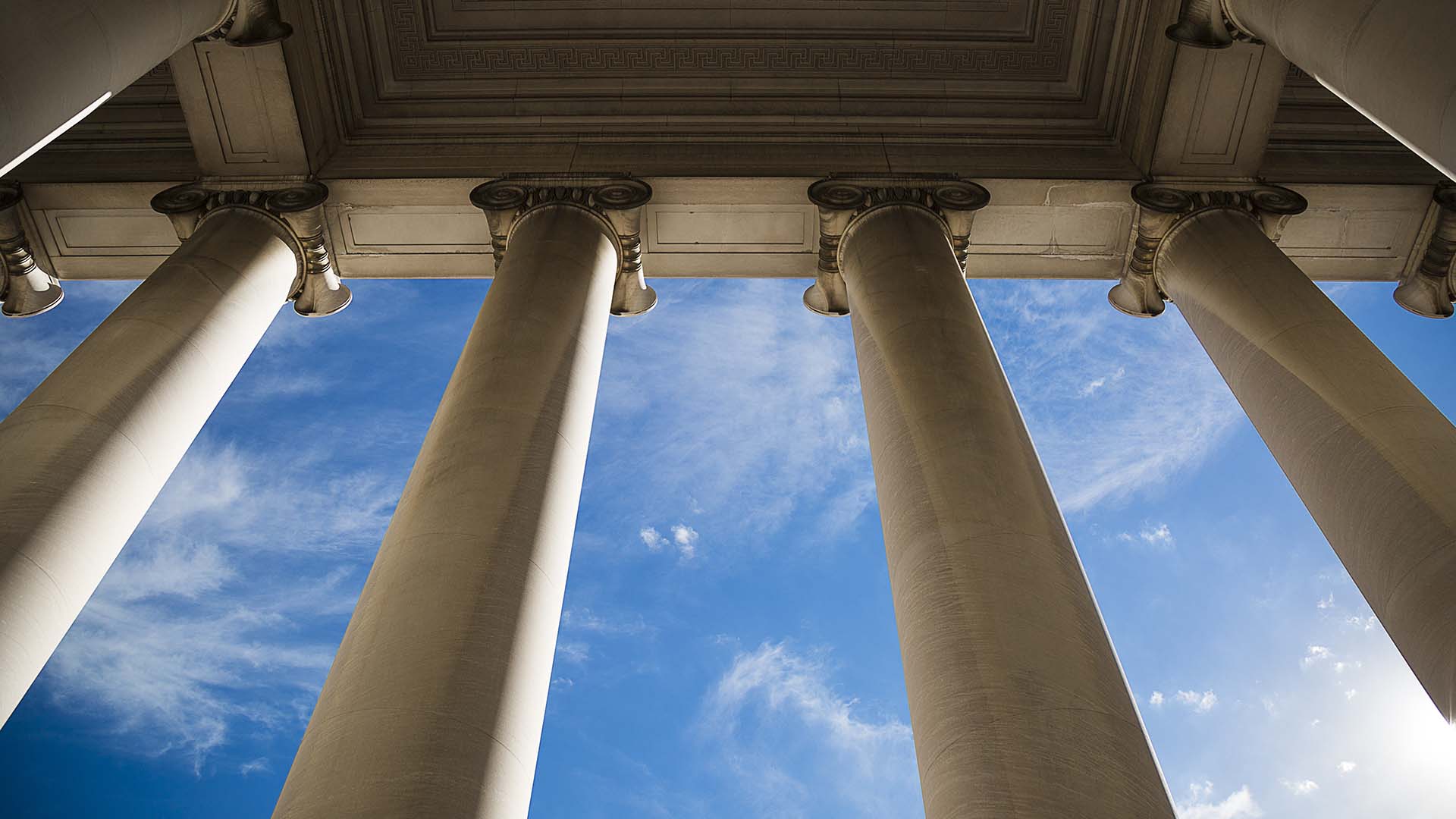 Court building's stone pillars viewed from below