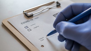 Gloved hand with COVID-19 checklist Gloved hand with COVID-19 checklist