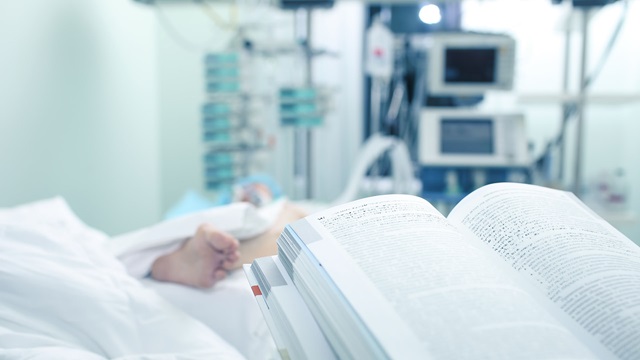 Patient in a hospital bed with a legal book