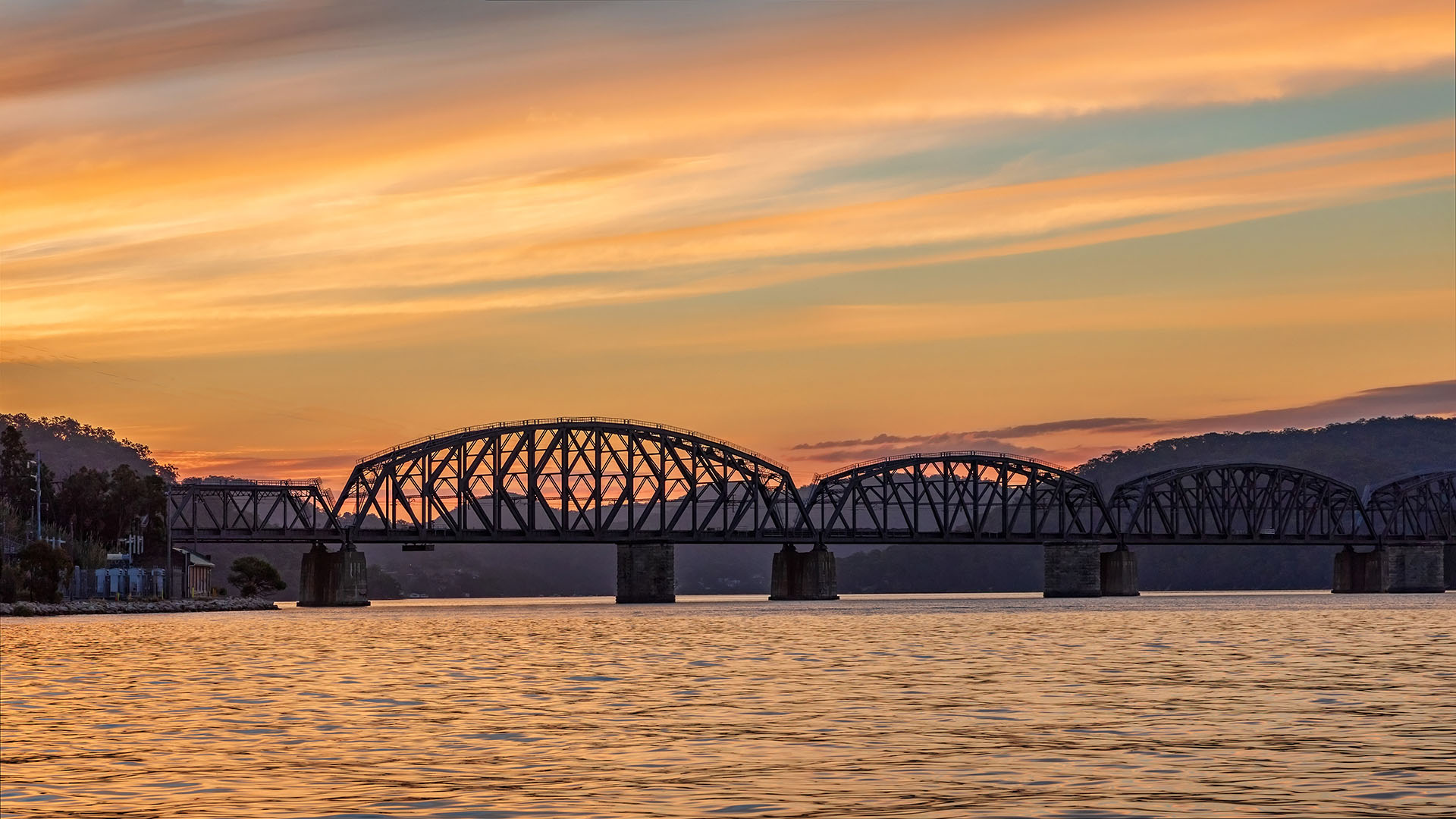 View of a industrial bridge at dusk over the water
