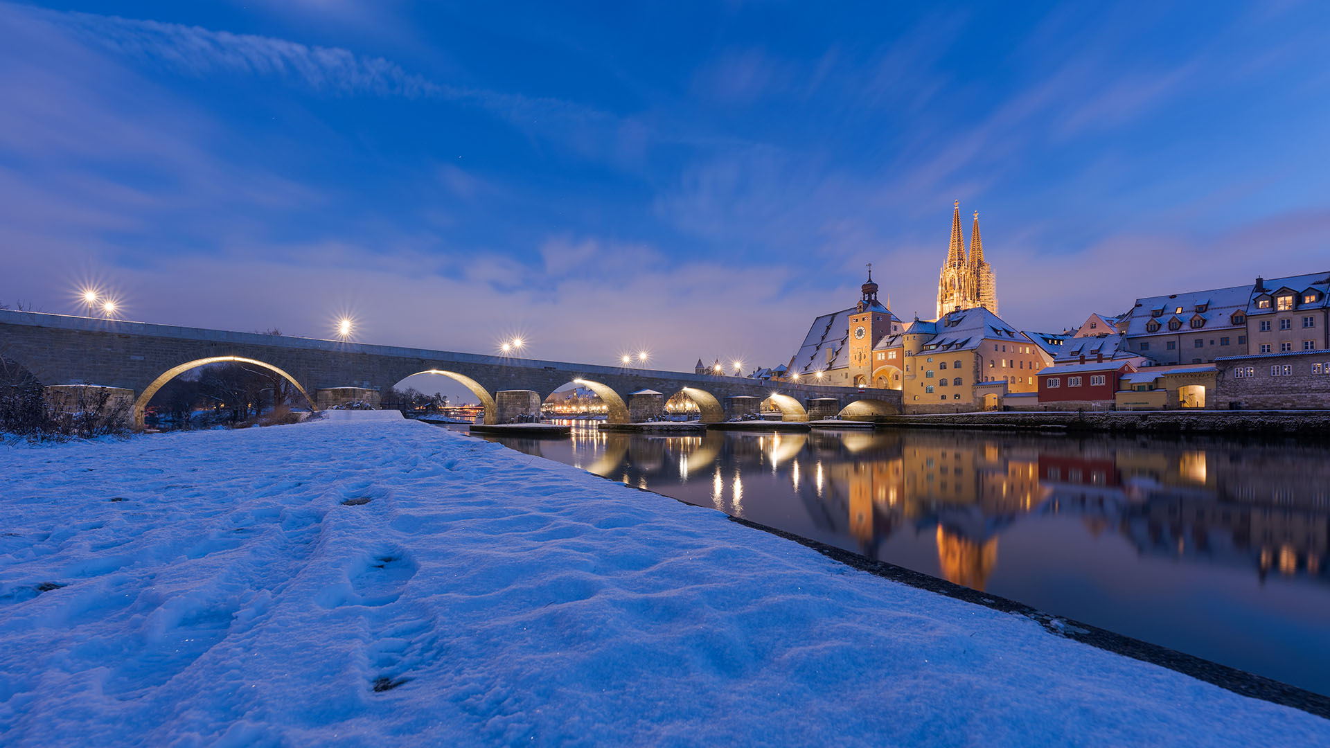 A snow-banked river with a bridge crossing in Germany