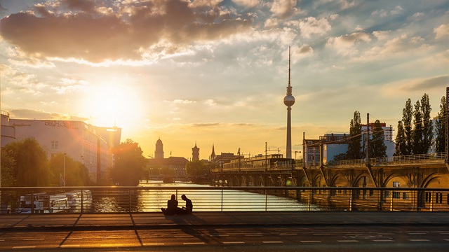City bridge at dusk with two people sitting on the curb