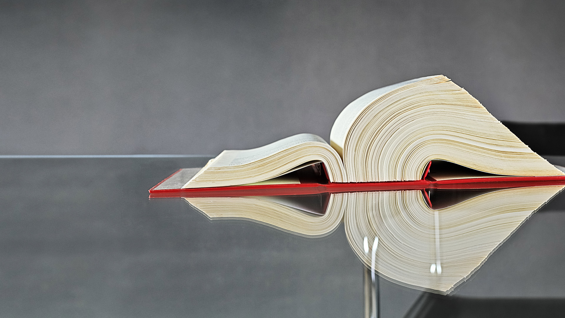 Large book on glass desk Large book on glass desk