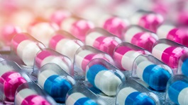 Multiple rows of blue and pink pharmaceutical drugs