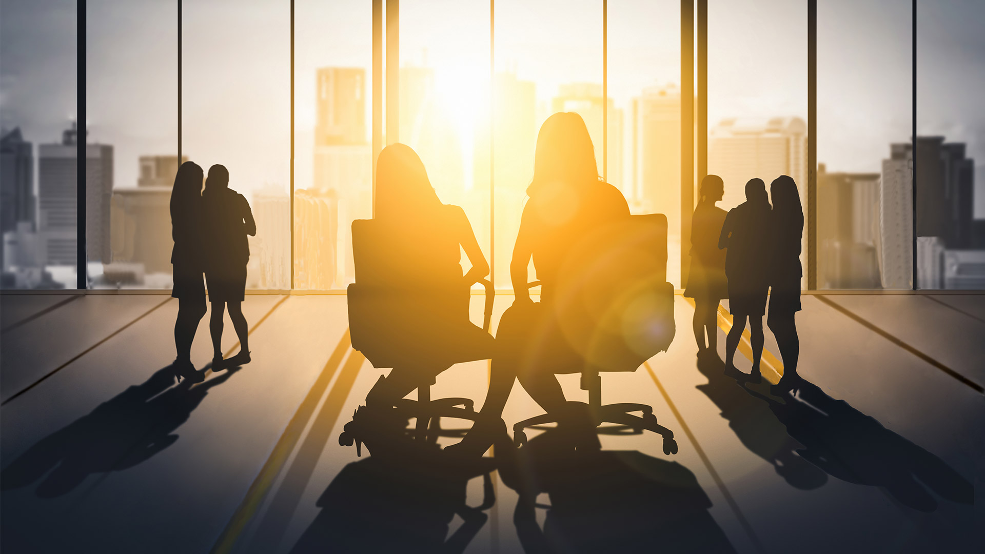 Women sitting and standing in a corporate setting Women sitting and standing in a corporate setting